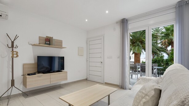 A modern living room with a flat-screen TV, a wooden coffee table, and a sofa with cushions. - La Vida Sin Limites "B" EMP (Empuriabrava)
