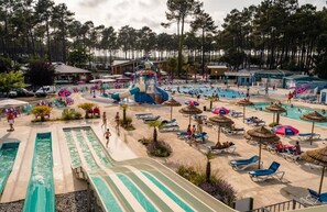 A water park with multiple slides and pools, surrounded by lounge chairs and umbrellas.