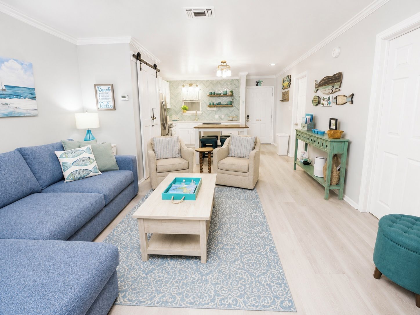 A living room with a blue sofa, a coffee table, and a patterned rug.