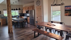 Une cuisine moderne avec des meubles en bois, des appareils électroménagers en acier inoxydable et un grand îlot central doté de tabourets de bar.