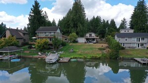 A residential area with houses, a dock, and a calm water body reflecting the surroundings. - Lakefront Cottage Near Crystal Mountain & Rainier (Sumner)