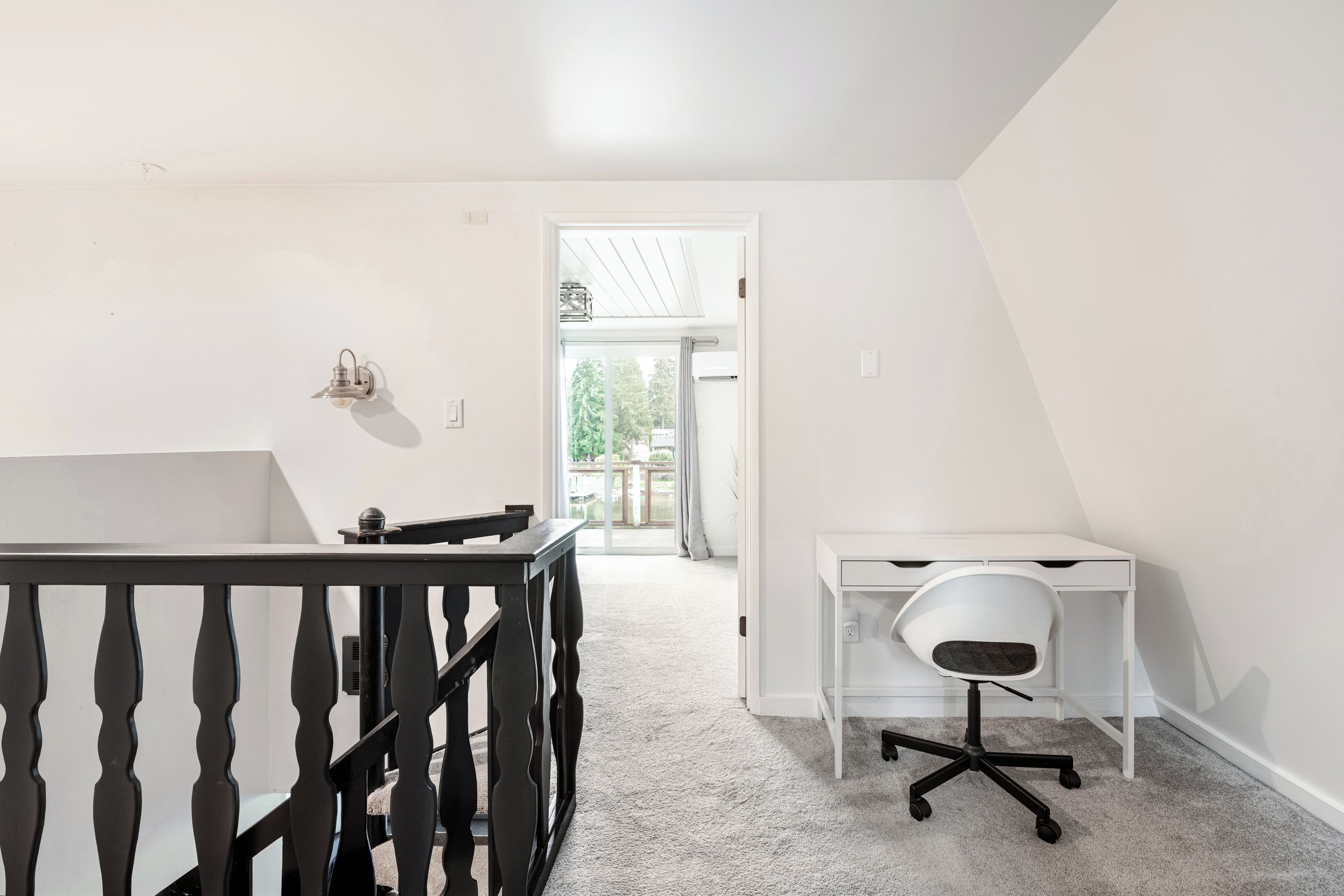 A room with a desk, chair, and a small table.