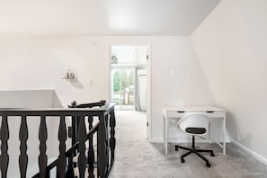 Une pièce comprenant un bureau, une chaise et une petite table.