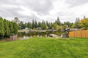 Un quartier résidentiel avec un lac, une jetée et une végétation luxuriante tout autour.