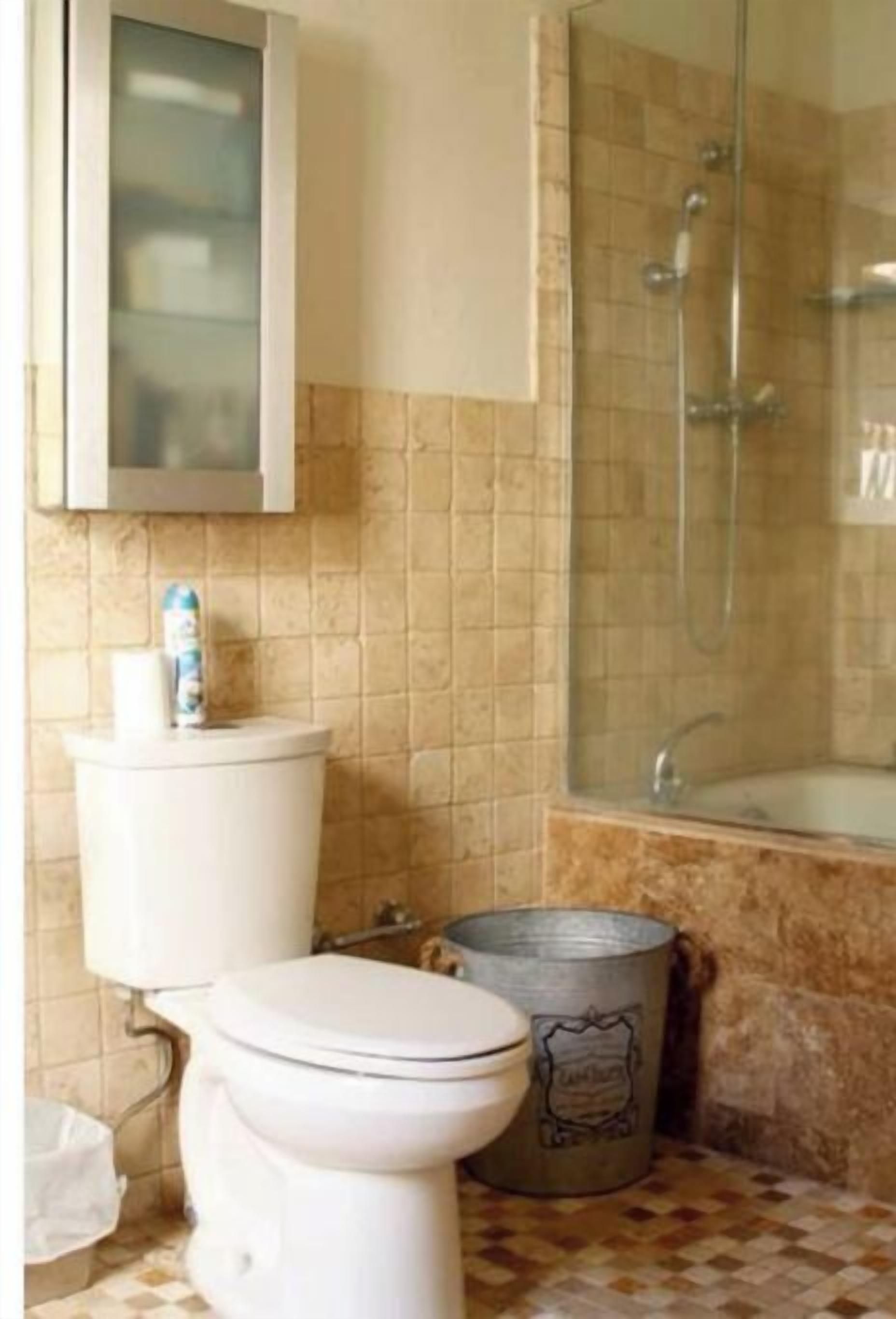 A bathroom with a toilet, a shower, and a sink.