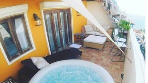 A balcony with a hot tub, outdoor seating, and a view of the sea. - Luxury House in Old San Juan (San Juan)