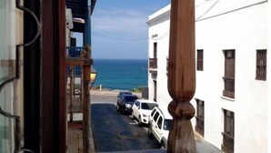 A narrow street with parked cars and a view of the sea. - Luxury House in Old San Juan (San Juan)