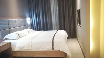 Une chambre d’hôtel moderne avec un lit en bois, une table de chevet et une grande fenêtre avec des rideaux.