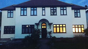 A two-story house with a symmetrical facade, a central entrance with an arch, and multiple windows. - Lovely and Comfortable 1-bed Apartment in Bromley (Bromley)