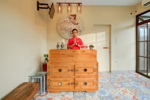 A reception desk with a wooden cabinet, a wall-mounted light fixture, and a door with a 'STAFF ONLY' sign. - Griya Gayatri Syariah (Ngaglik)