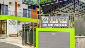 A gated entrance to a building with a sign for 'GRIYA GAYATRI KOST EXCLUSIVE' and contact information. - Griya Gayatri Syariah (Ngaglik)