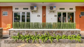A reception area with a stone bench, air conditioning units, and a green wall. - Griya Gayatri Syariah (Ngaglik)