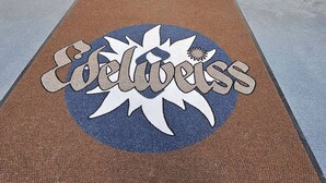 A double door entrance with a doormat featuring the word "Columbus" and a star design.