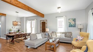 A spacious living room with a wooden ceiling, a dining area with a wooden table and chairs, and a comfortable seating area with a sofa and armchairs. - The Rustic Rose - 4 Bedroom House w/ HOT TUB near Downtown (Walla Walla)