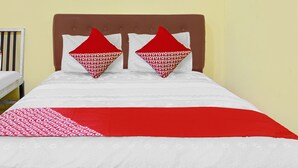 A bed with a white and red bedspread, two red pillows with white text, and a brown headboard. - OYO 90065 Homestay Barokah Park (Asembagus)