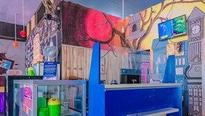 A colorful room with a mural, a TV, and a refrigerator. - OYO 90065 Homestay Barokah Park (Asembagus)