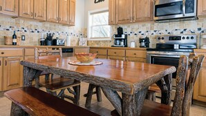 A kitchen with wooden cabinets, a stone countertop, and a central island with a bowl.