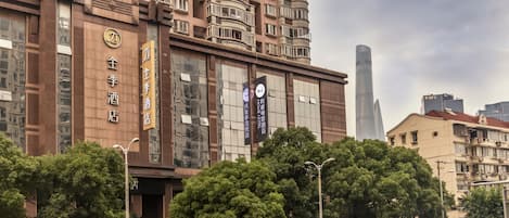 Un hôtel à plusieurs étages doté de balcons, de grandes fenêtres et d’une signalétique indiquant les équipements et services proposés.
