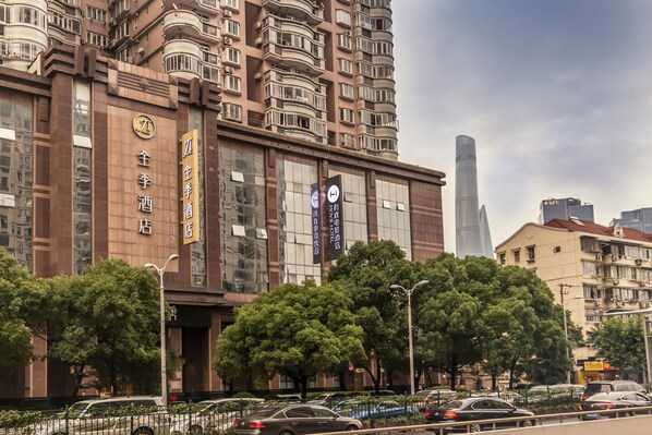 A multi-story hotel with balconies, large windows, and signage indicating amenities. - Ji Hotel Shanghai The Bund Town City God Templ (Shanghai)