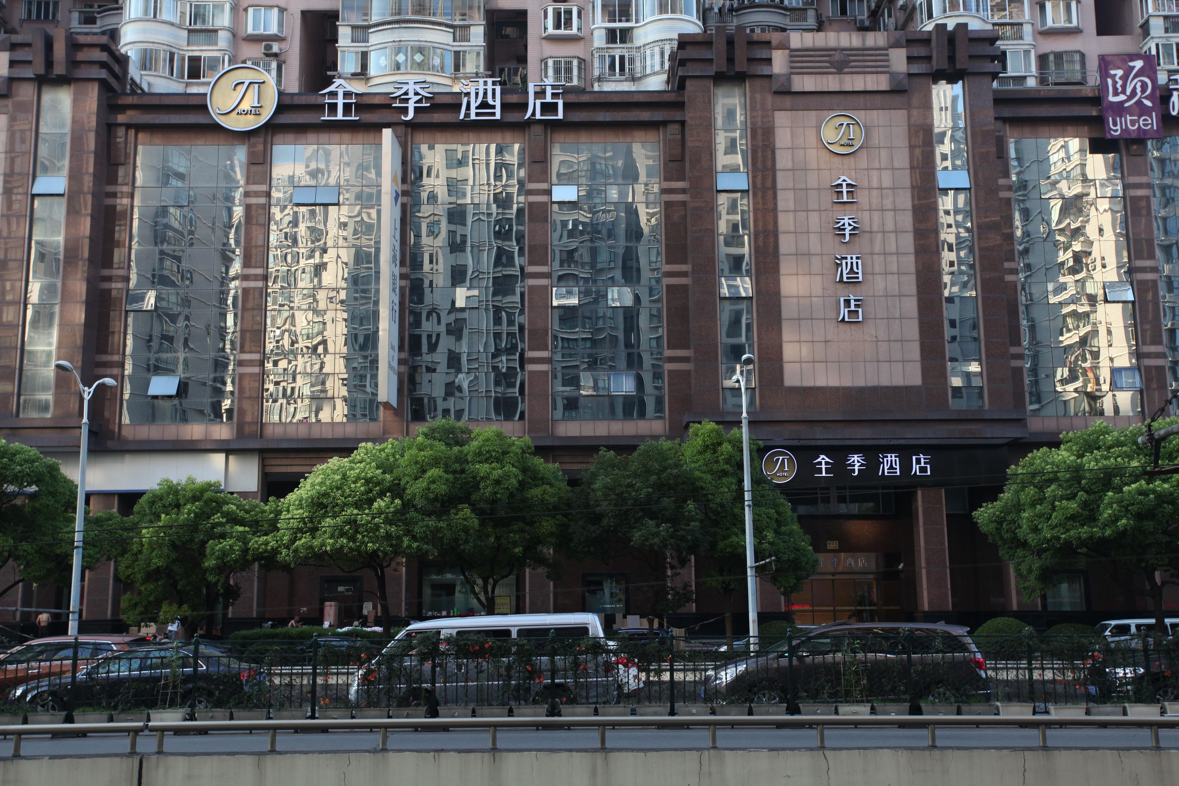 A hotel facade with large reflective windows, a prominent sign, and a gated entrance.