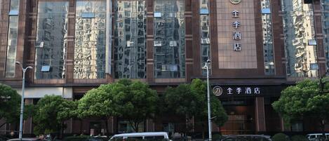 A hotel facade with large reflective windows, a prominent sign, and a gated entrance.