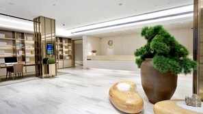 A modern hotel reception area with a large desk, a computer, and a reception counter. - Ji Hotel Shanghai The Bund Town City God Templ (Shanghai)