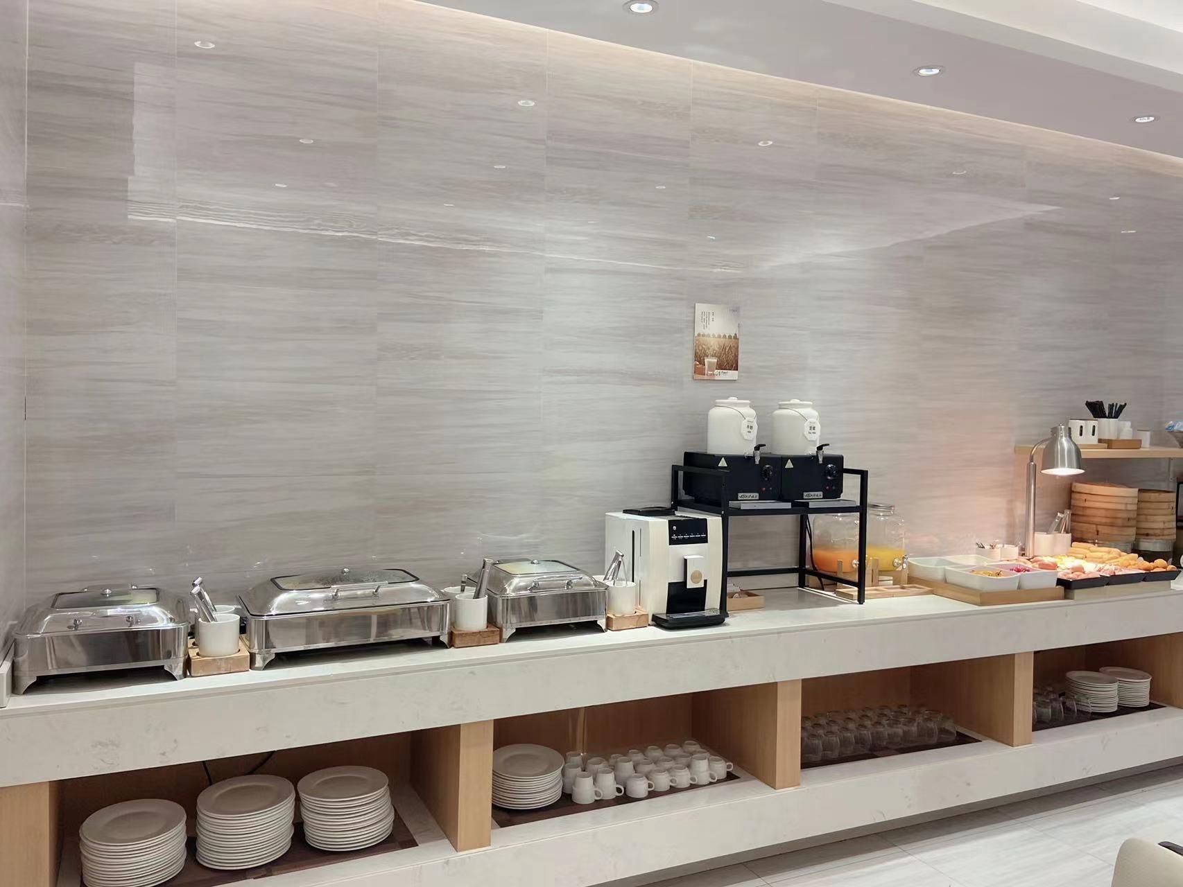 A buffet setup with various food containers and a coffee machine.