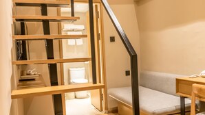 A modern staircase with wooden steps and black railings leading to a loft bedroom area. - Ji Hotel Shanghai The Bund Town City God Templ (Shanghai)