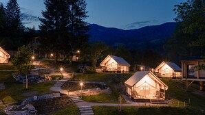 Una serie de cabañas de madera con porches adosados, rodeadas por un jardín cuidado y un sendero de piedra que lleva a la entrada.