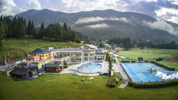 Un hotel con piscina, area esterna coperta e vista sulle montagne.