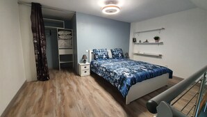 A bedroom with a bed, bedside table, lamp, and a ceiling light. - Duplex Nights & Days in Nuits-Saint-Georges (Nuits-Saint-Georges)