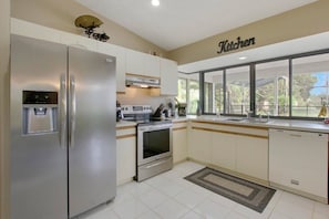 Eine Küche mit Edelstahl-Kühlschrank, eingebautem Backofen, Herd und Geschirrspüler.