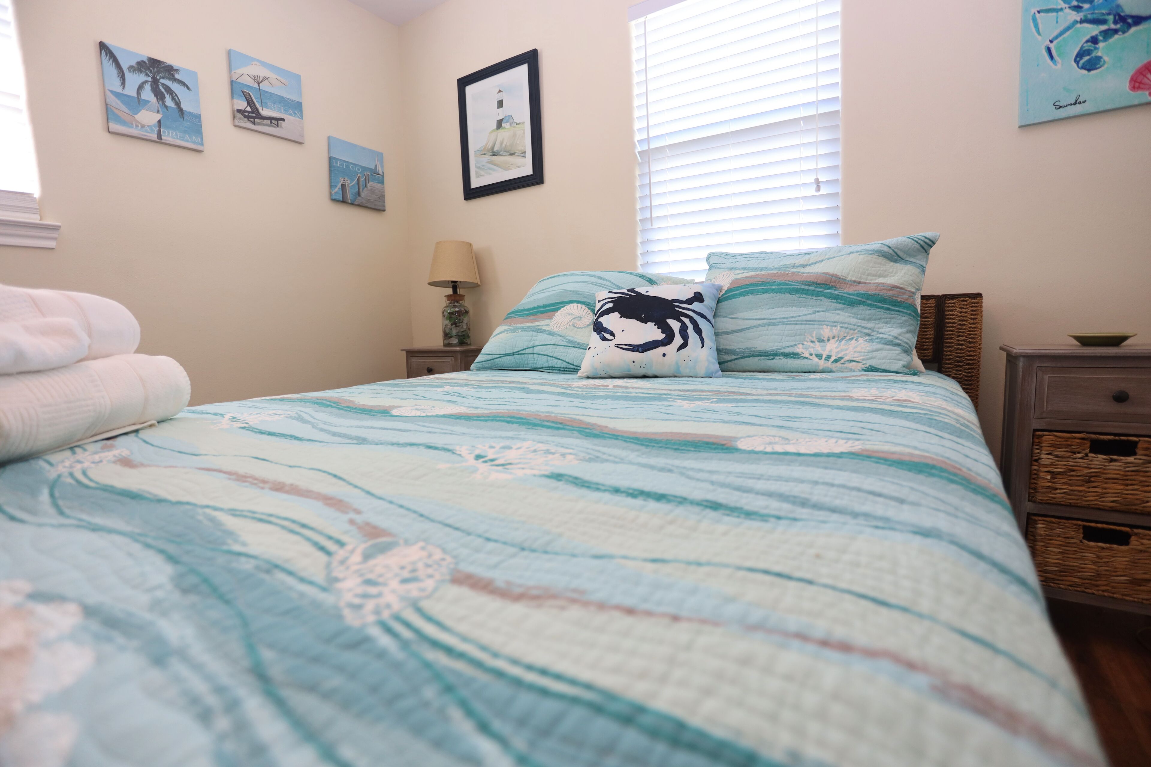 Un dormitorio con cama, mesita de noche, lámpara y decoración en la pared.