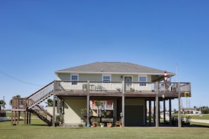 A two-story building with a balcony, a staircase, and a flag.