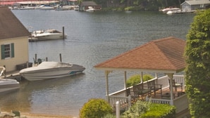 A lakeside property with a dock, a covered pavilion, and boats. - Waterfront Smith Cove Lake House includes dock (Gilford)