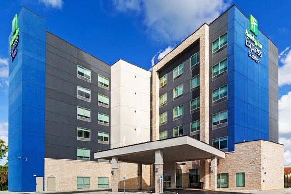 A Holiday Inn Express hotel with a modern design, featuring a prominent blue and beige color scheme, multiple floors, and a covered entrance area. - Holiday Inn Express & Suites Houston – Downtown North by IHG (Houston)