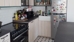 Une cuisine de taille réduite équipée d’une cuisinière, d’un four, d’un évier et d’un réfrigérateur.