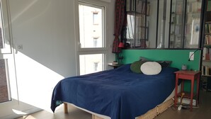 Une chambre à coucher avec un lit, une table de chevet, une lampe et une bibliothèque.