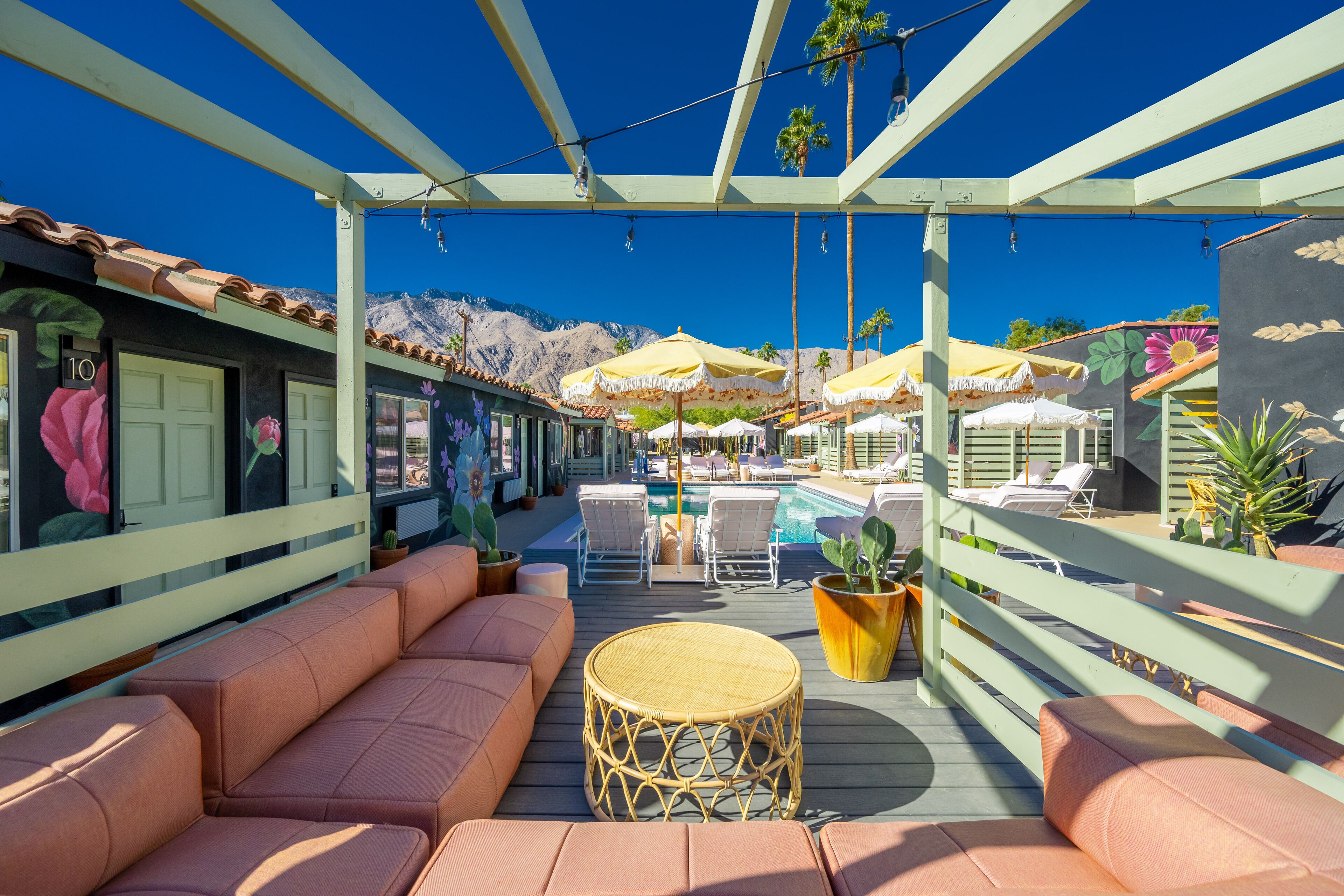 A rooftop terrace with outdoor seating, umbrellas, and a pool.