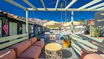 A rooftop terrace with outdoor seating, umbrellas, and a pool.