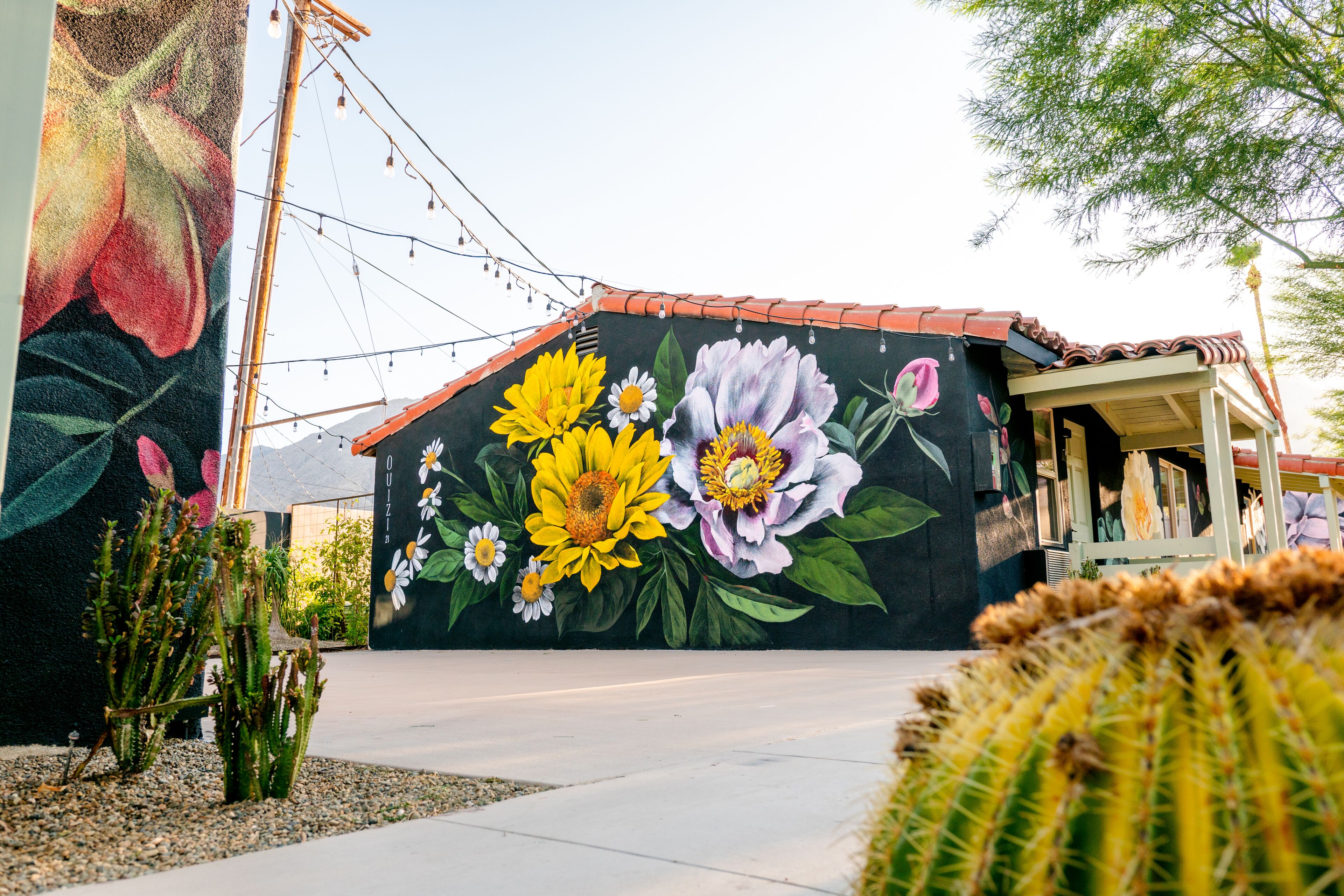 A building with a mural of flowers and cacti.