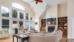 A spacious living room with a large sectional sofa, a fireplace, and a TV. - 8th And Sound: Elevator | Pool | Hot Tub (Corolla)