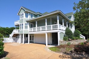 A two-story house with a covered front porch and a garage. - 40-Love is a:  Soundfront | Private Pool | Spa (Corolla)