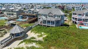 Un quartier résidentiel situé sur la côte, avec des propriétés en bord de mer, notamment des maisons dotées de balcons et d’une piscine.