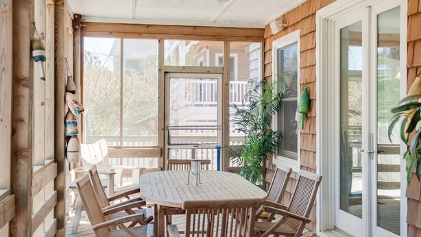 A covered patio with a wooden table and chairs, a ceiling fan, and a view of the neighborhood. - Reminiscent: Oceanside, Private Pool, Spa (Nags Head)