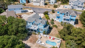 A large blue house with a swimming pool and a fenced deck area. - Treasured Dreams: Private pool, Short Drive to Beach, Great Community Amenities! (Corolla)