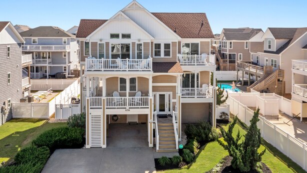 A multi-story residential building with a central courtyard, balconies, and a swimming pool. - A Ruff Life: Saltwater Pool, Hot Tub, 500 ft. to the Beach, Dog-friendly (Corolla)