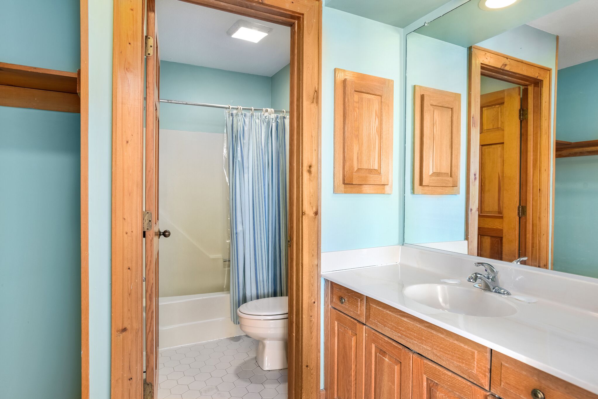 A bathroom with a shower, toilet, and sink.