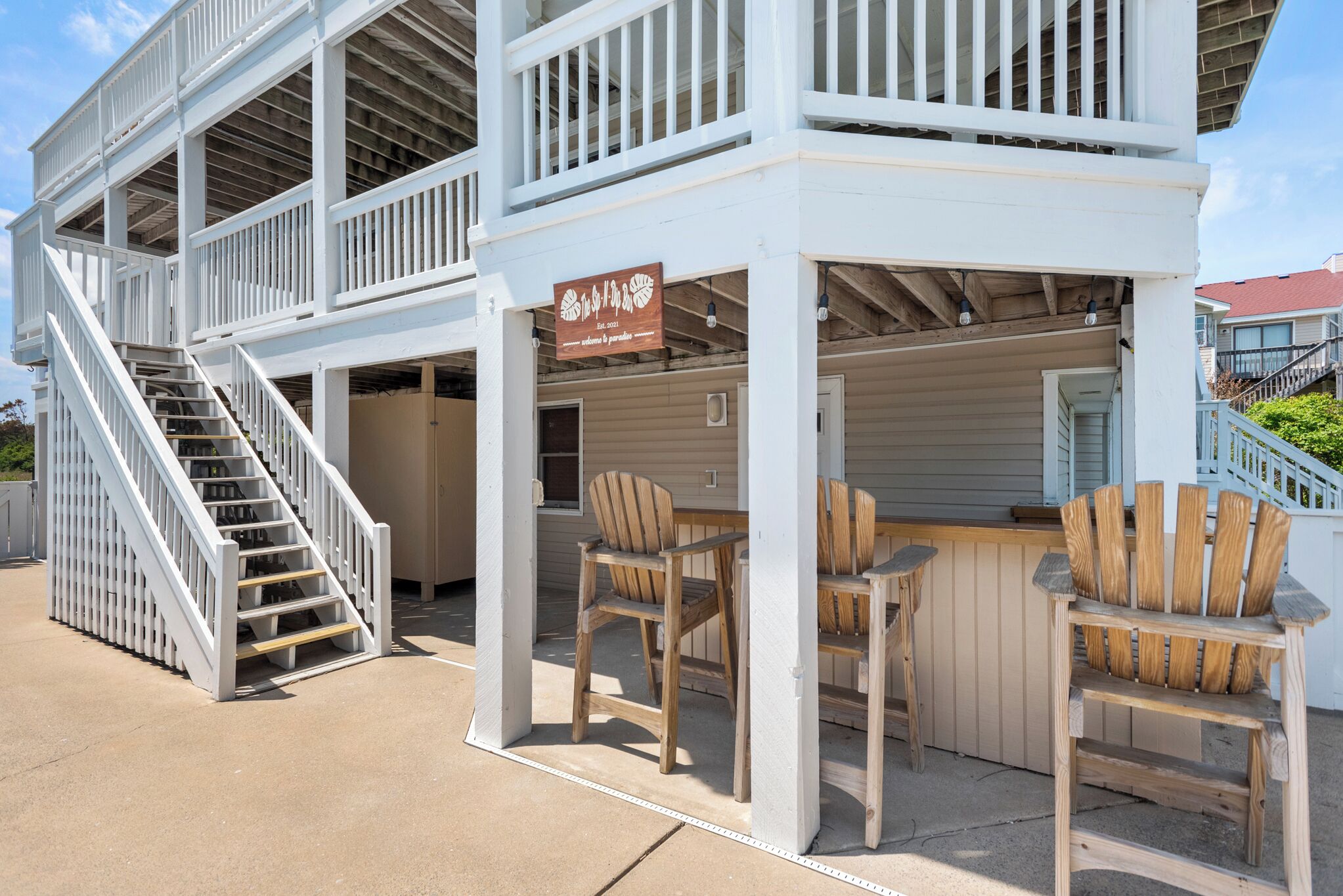 A two-story building with a wooden deck and a bar area.