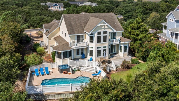 A large house with a swimming pool, multiple decks, and a view of the ocean. - Sea-Esta: Private Pool | Hot Tub | Foosball Table (Corolla)